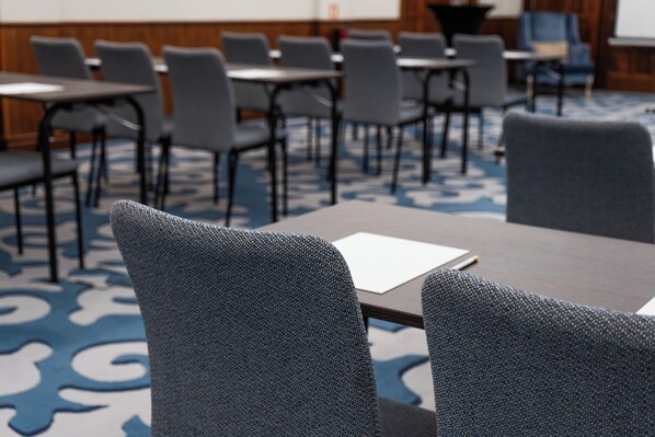 A conference room with rows of grey chairs and tables, a whiteboard, and a carpet with a blue pattern. - InterContinental Porto - Palacio das Cardosas by IHG (Porto)