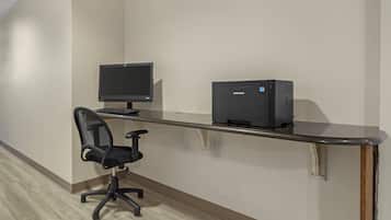 A workspace with a computer monitor, printer, and office chair.