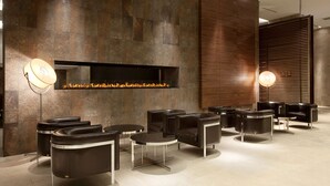 Ein moderner Lounge-Bereich mit Ledersitzmöbeln und einer Wand aus Stein.