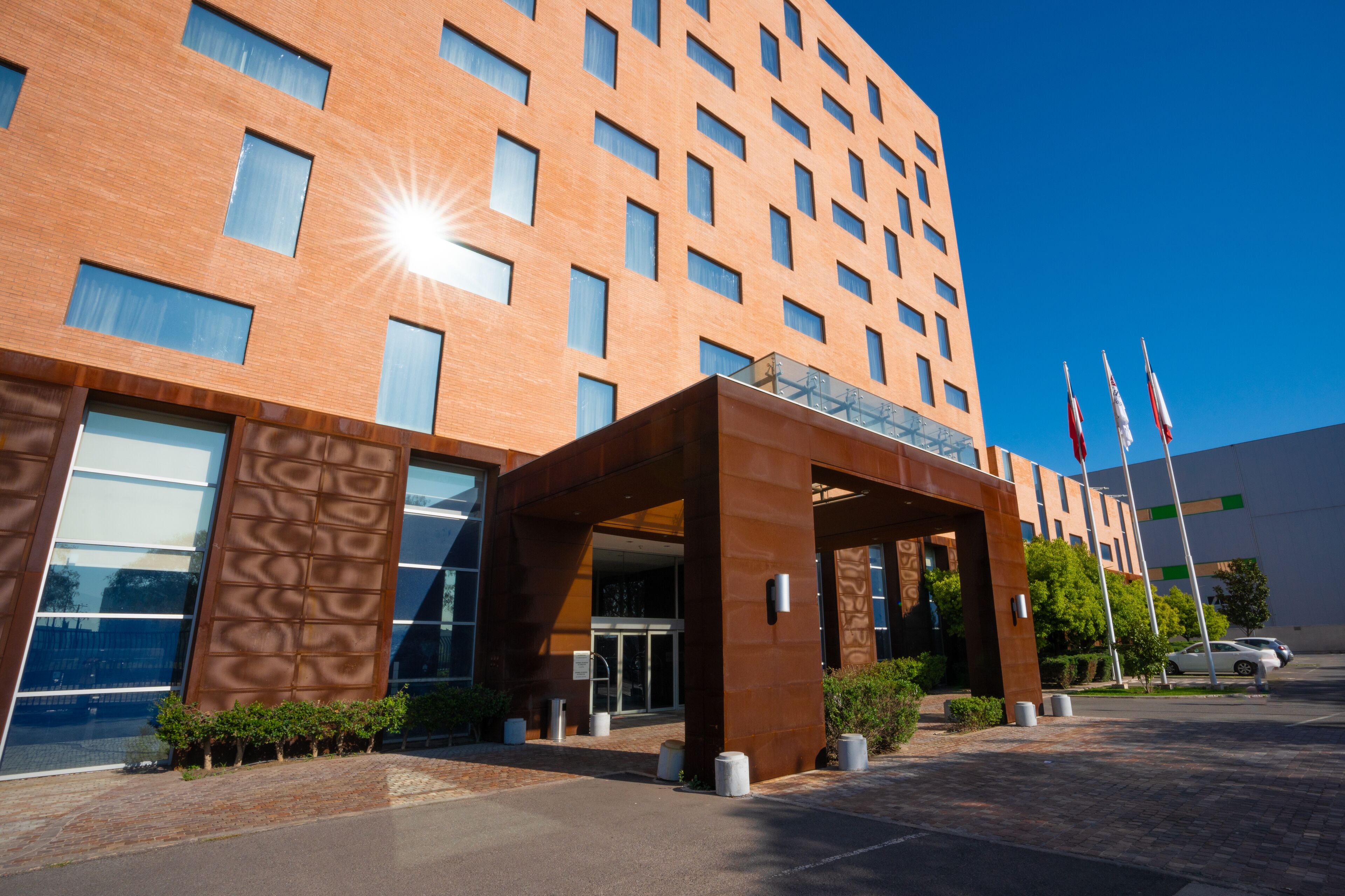 A modern hotel with a brick facade, large windows, and a covered entrance area.