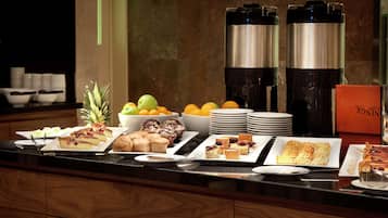 Un bufé con diversas opciones de comida y dispensadores de café.