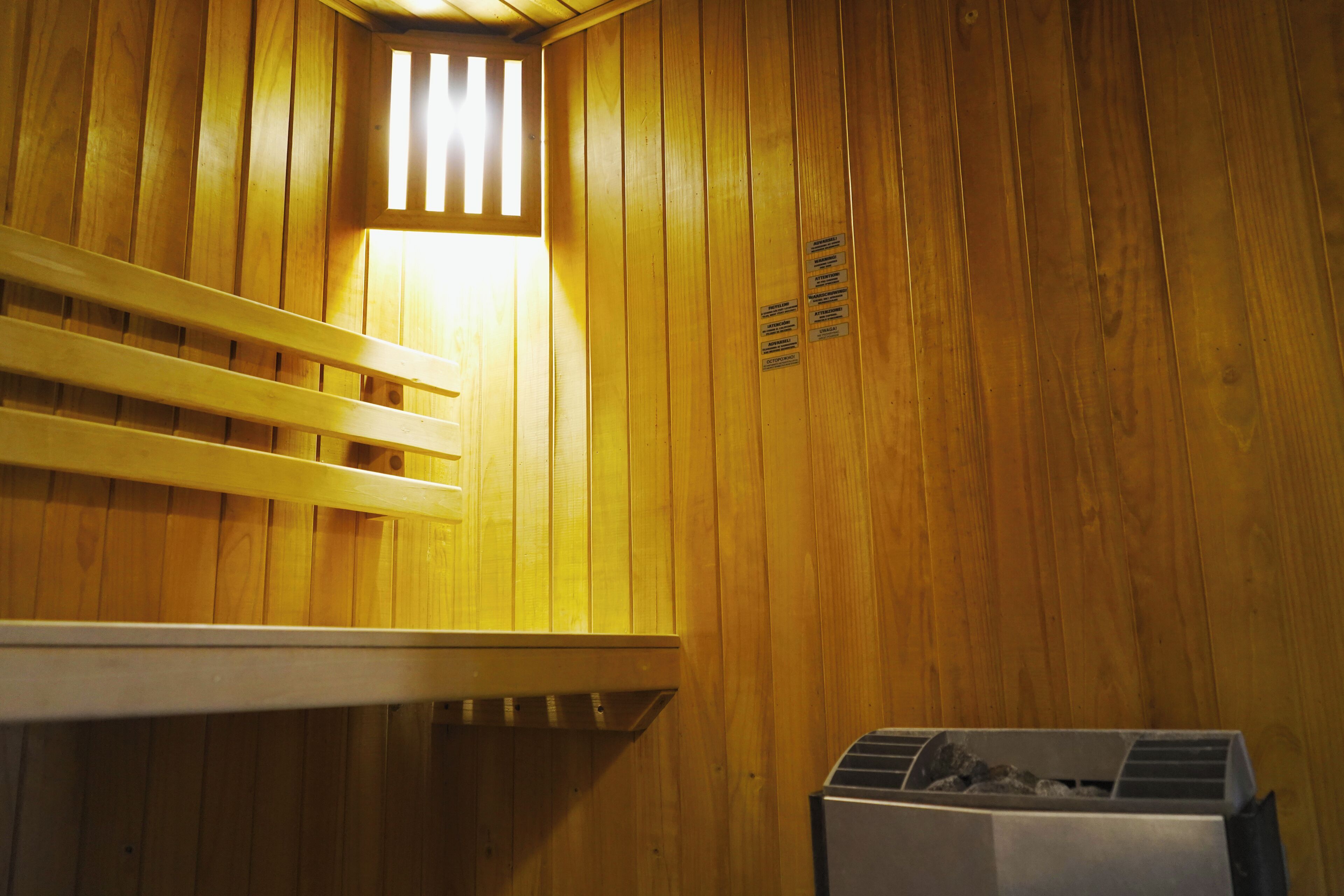 Een sauna met houten wanden, een bank en een heater.