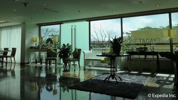 A spacious lobby with a large window, a reception desk, and a seating area with chairs and tables.
