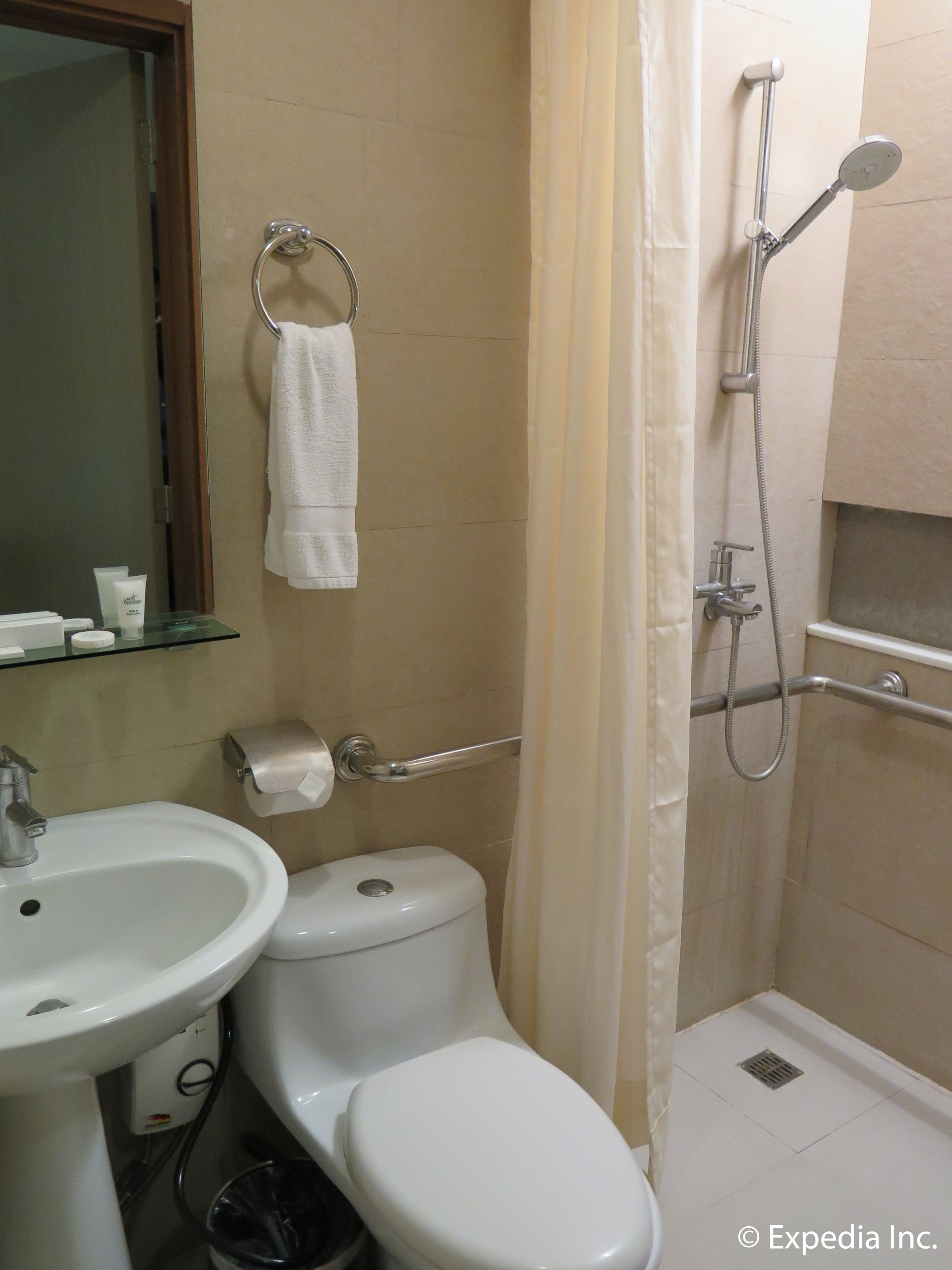 Un baño con lavamanos, inodoro y ducha.