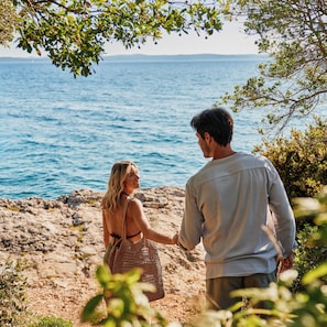 A couple standing on a rocky beach with the sea in the background. - Falkensteiner Hotel & Spa Iadera (Zadar)