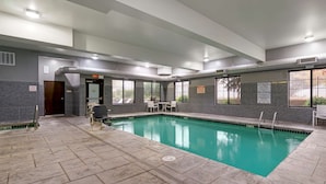 An indoor swimming pool with clear water, surrounded by stone tiles and equipped with a lifeguard chair. - Best Western Plus Lacey Inn & Suites (Olympia)