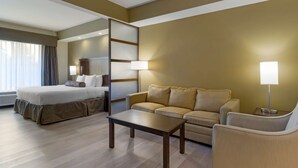 A hotel room with a bed, a sofa, a table, and a lamp. - Best Western Plus Lacey Inn & Suites (Olympia)
