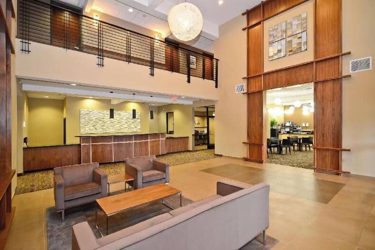 A spacious lobby with seating areas, a reception desk, and a view into the dining area.