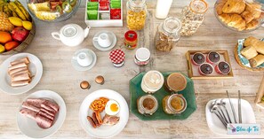 Ein reichhaltiges Frühstücksbuffet mit Speisen und Getränken auf einem Holztisch.