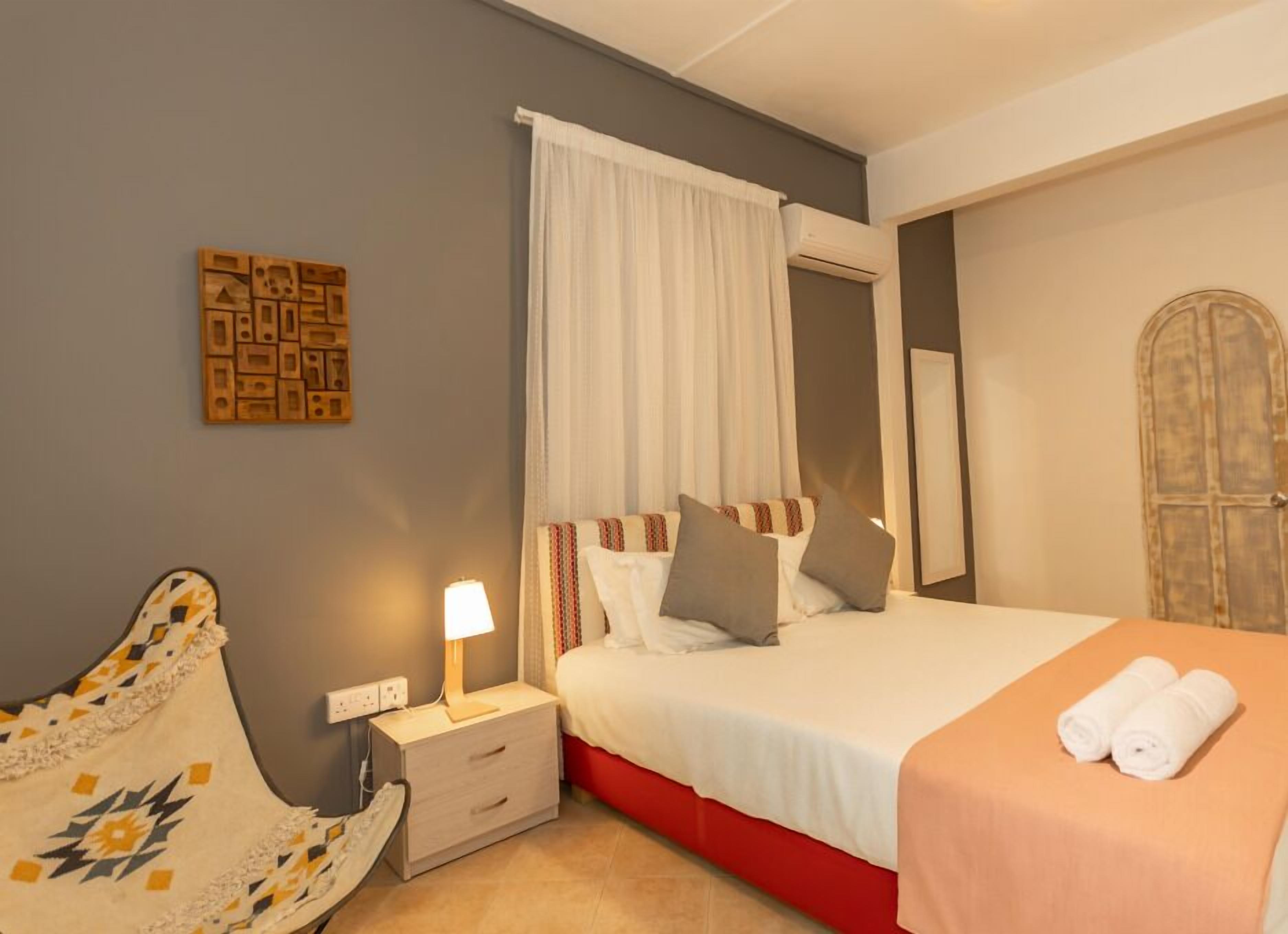 Une chambre à coucher avec un lit, une table de chevet, une lampe et une porte.