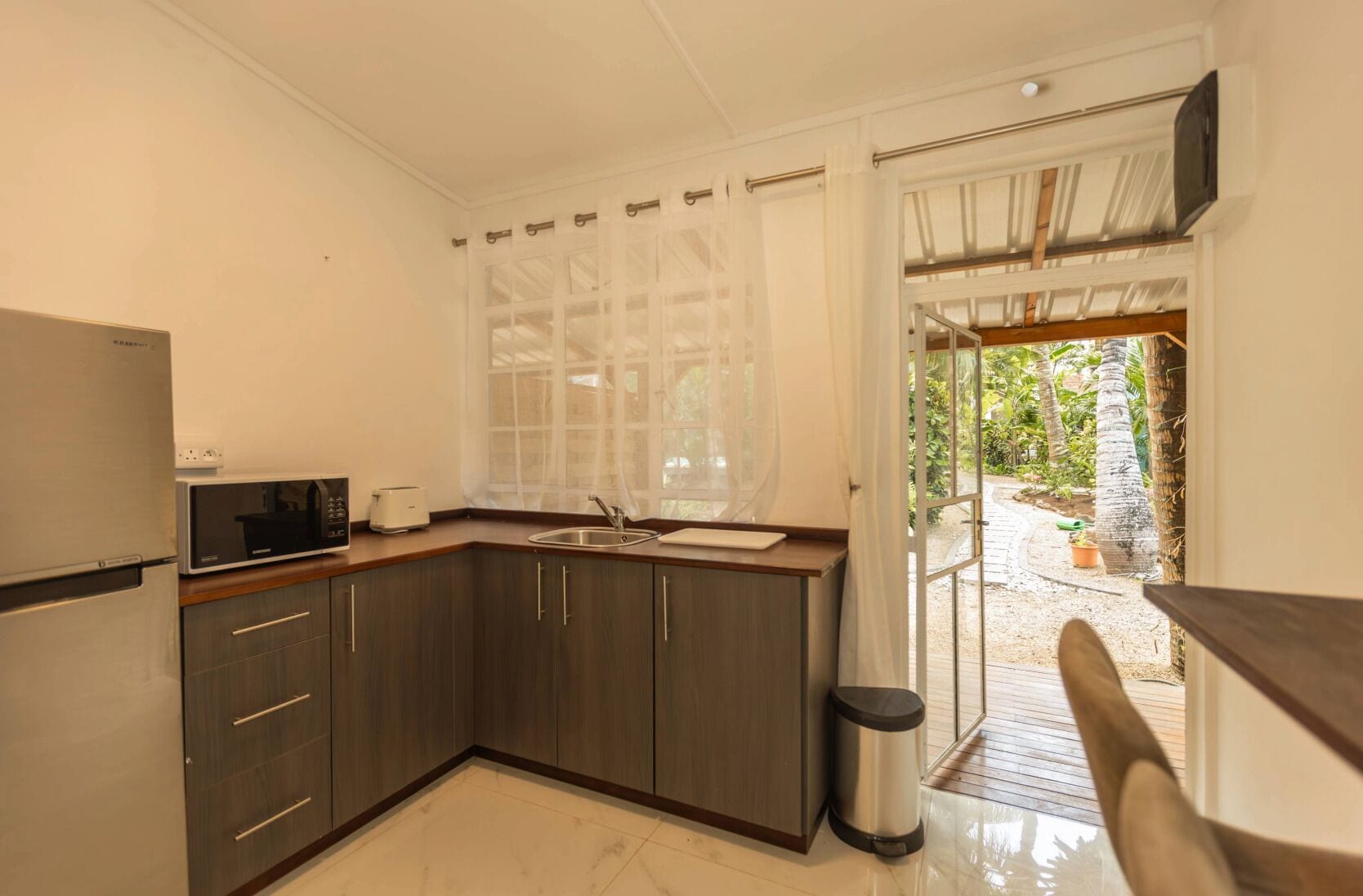 A compact kitchen with a microwave, toaster, and sink.