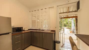 A compact kitchen with a microwave, toaster, and sink.