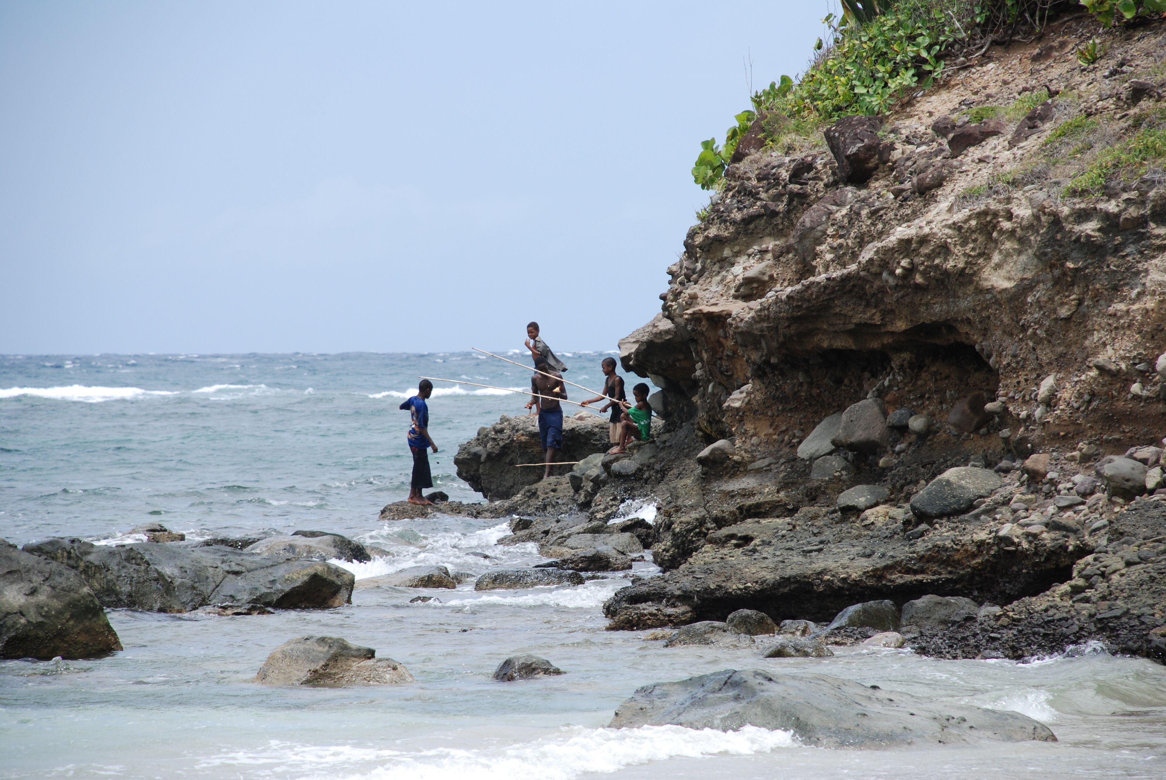 Un rivage rocheux où des personnes pêchent.
