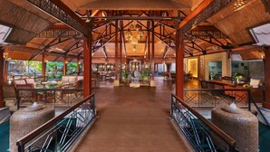 A spacious lobby with a high ceiling, wooden beams, and a central open area with seating. - Ananta Spa and Resorts (Pushkar)