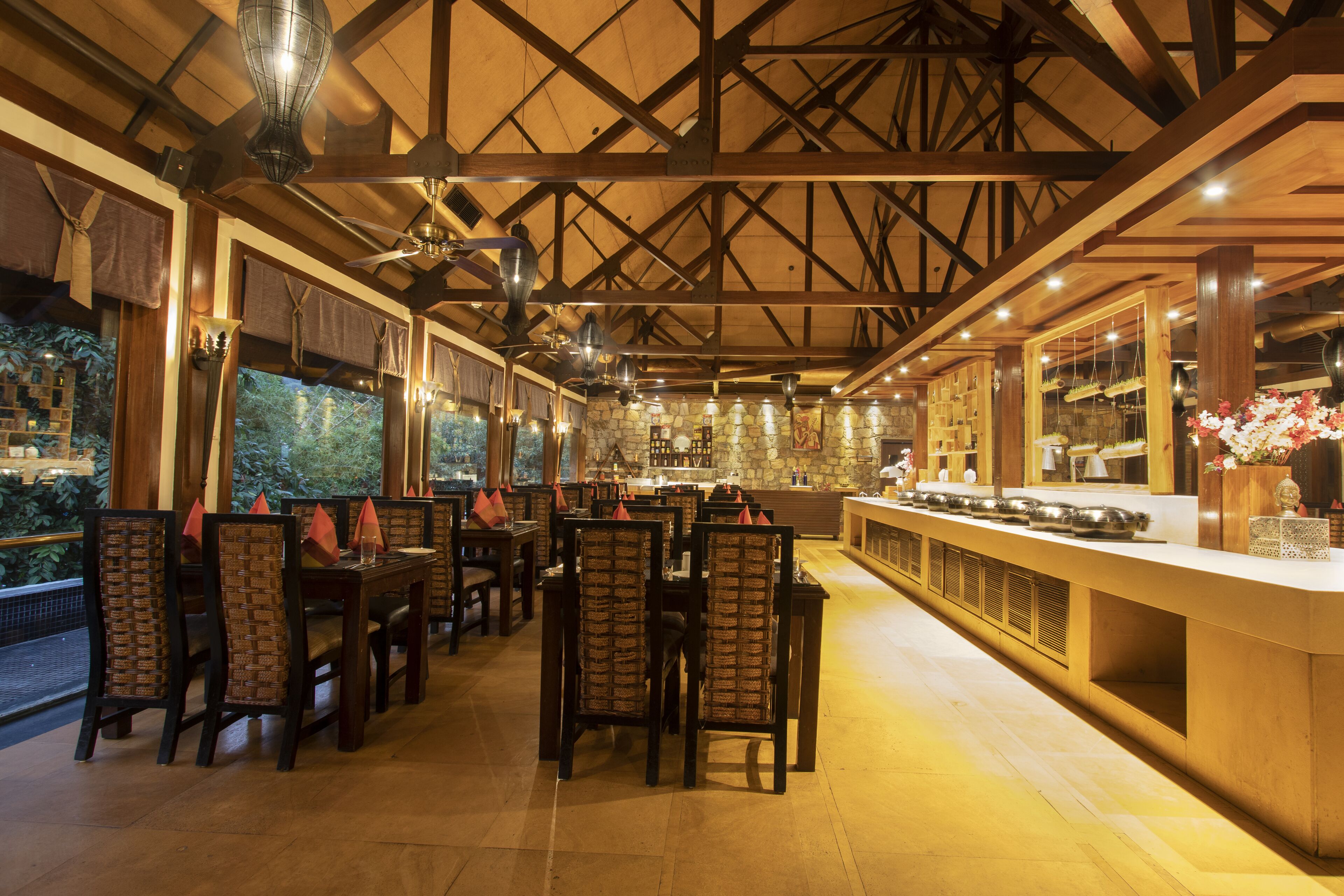 A restaurant with wooden beams, stone walls, and a bar area.