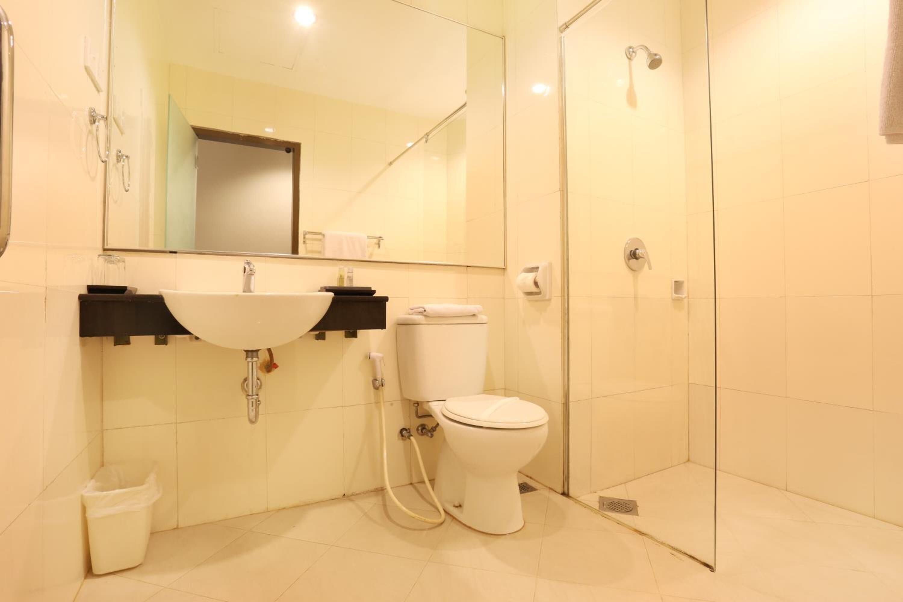 Un baño moderno con lavamanos, inodoro y ducha.
