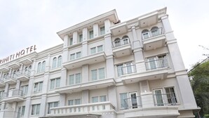 A multi-story hotel with balconies and a sign reading "TRINITY HOTEL". - Triniti Hotel Batam (Batam)