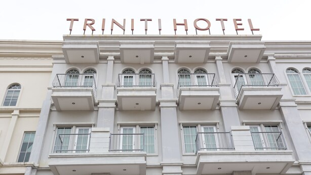 A building with the sign "TRINITI HOTEL" at the top. - Triniti Hotel Batam (Batam)