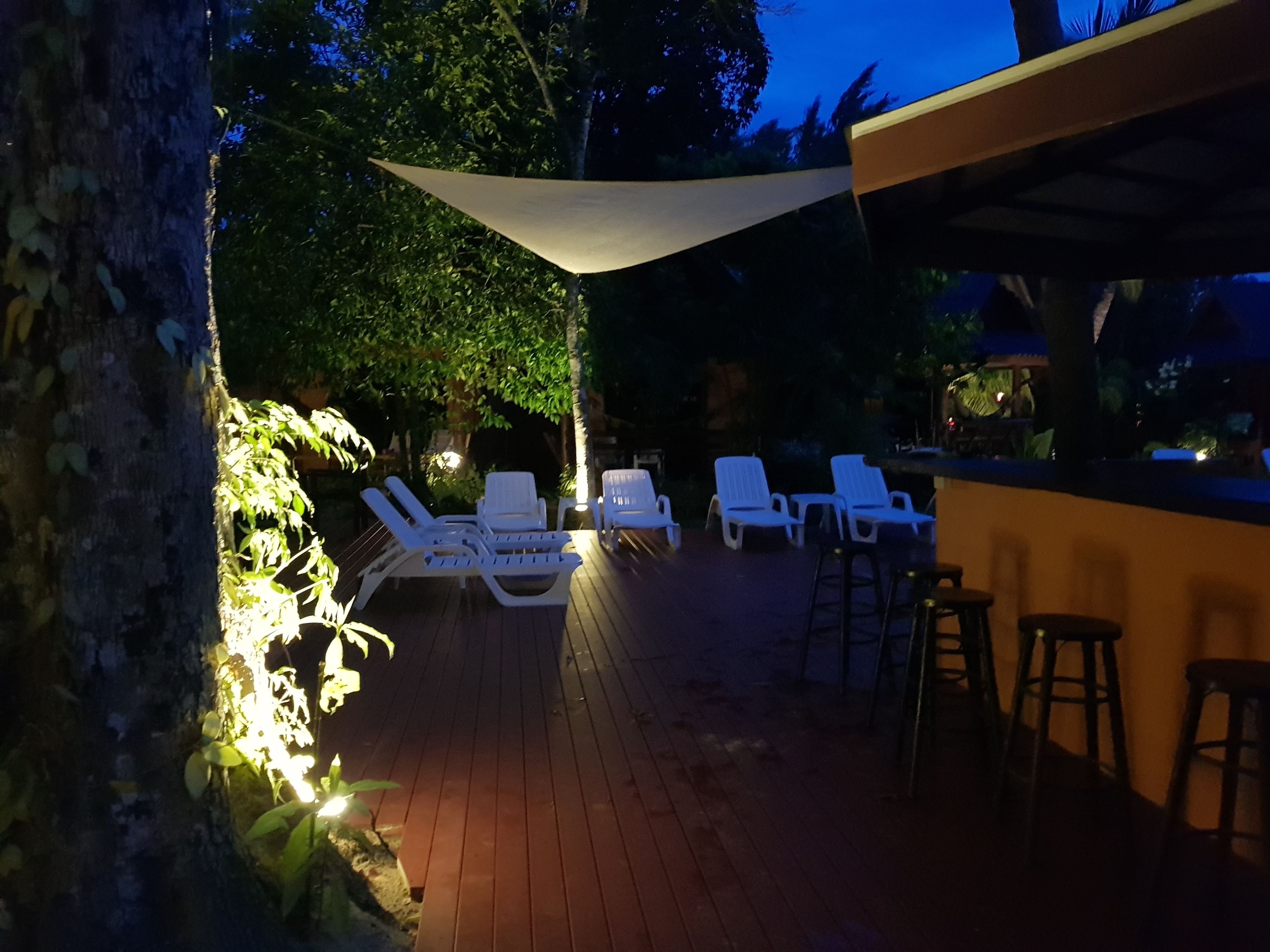 A patio area with white lounge chairs and a bar area.