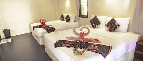 Une chambre d’hôtel avec deux lits, une fenêtre avec des rideaux, un climatiseur fixé au mur et une petite table avec une poubelle.