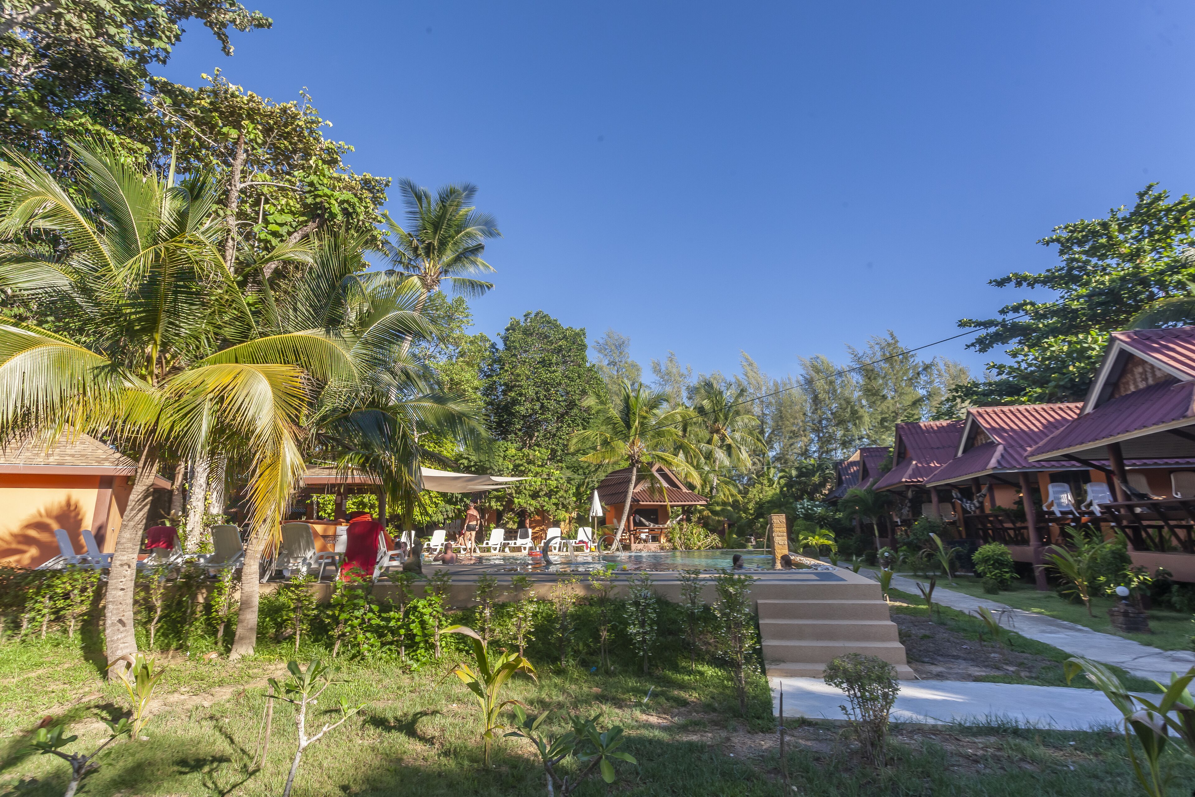 Et resort med pool, palmer og bungalows.