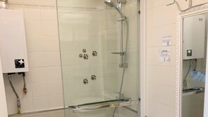 A modern bathroom with a glass-enclosed shower, a toilet, and a sink.