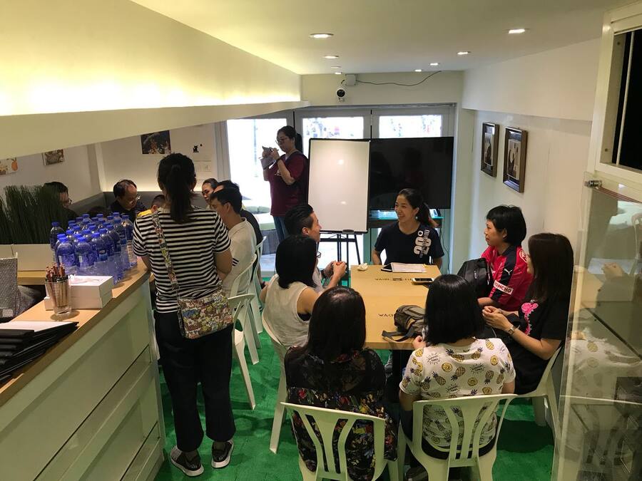 A conference room with a long table, white chairs, and a whiteboard.