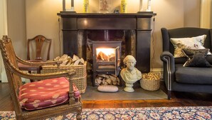 A cozy living room with a fireplace, two lamps, a statue, and a sofa. - Six Brunton Place (Edinburgh)