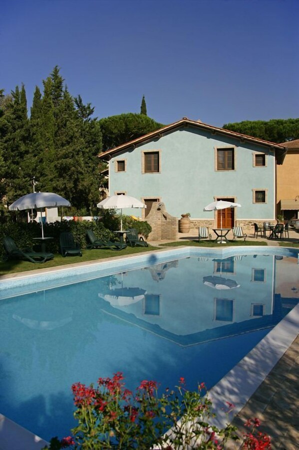 حمّام سباحة خارجي، مظلات على حمّام السباحة، مقاعد للتشمس