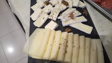 Ein Käseplatte mit verschiedenen Käsesorten und Walnüssen auf einer schwarzen Platte.