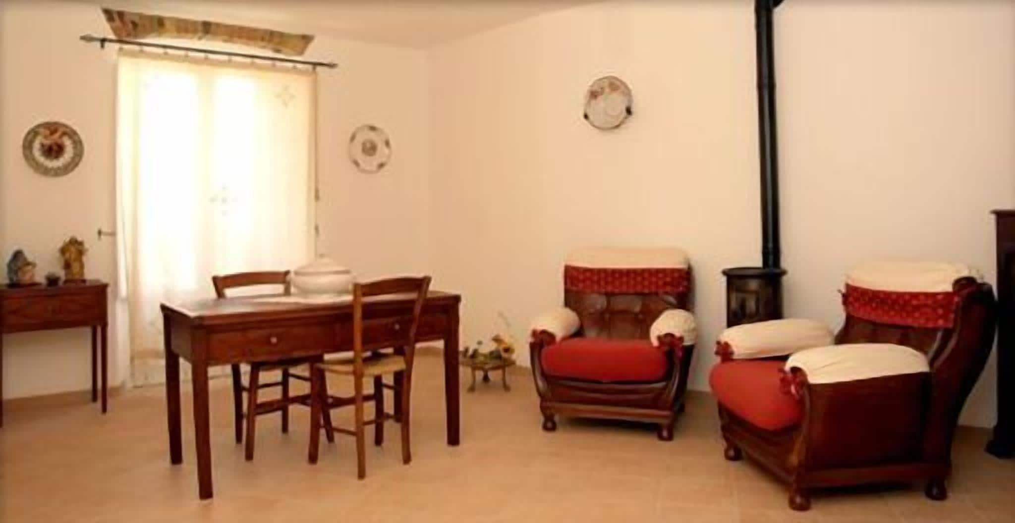 Una sala de estar acogedora con una mesa de comedor, dos sillones, un sofá y una chimenea.