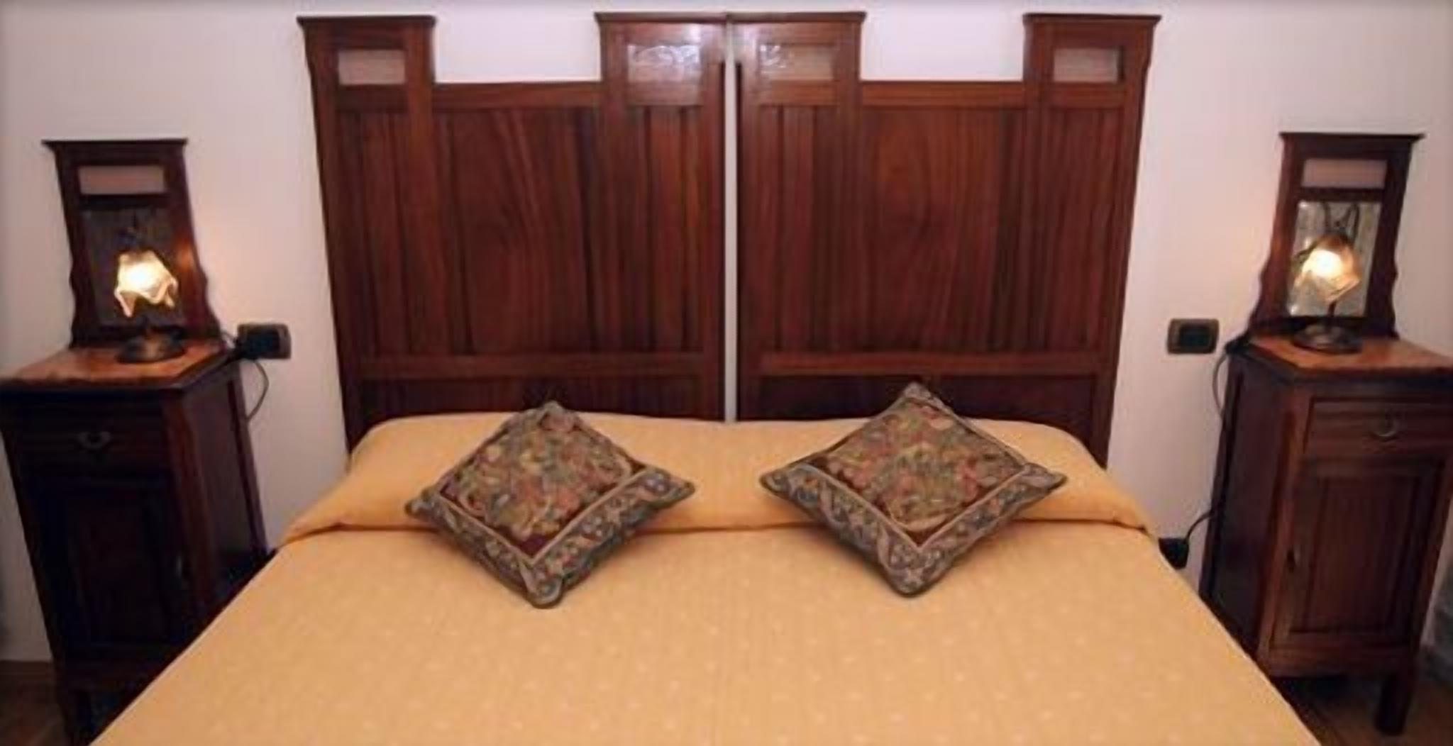 A double bed with a wooden headboard and two matching nightstands.