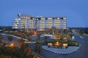 A multi-story hotel with a modern design, featuring a central courtyard and a parking area. - Labersa Grand Hotel & Convention Center (Pekanbaru)