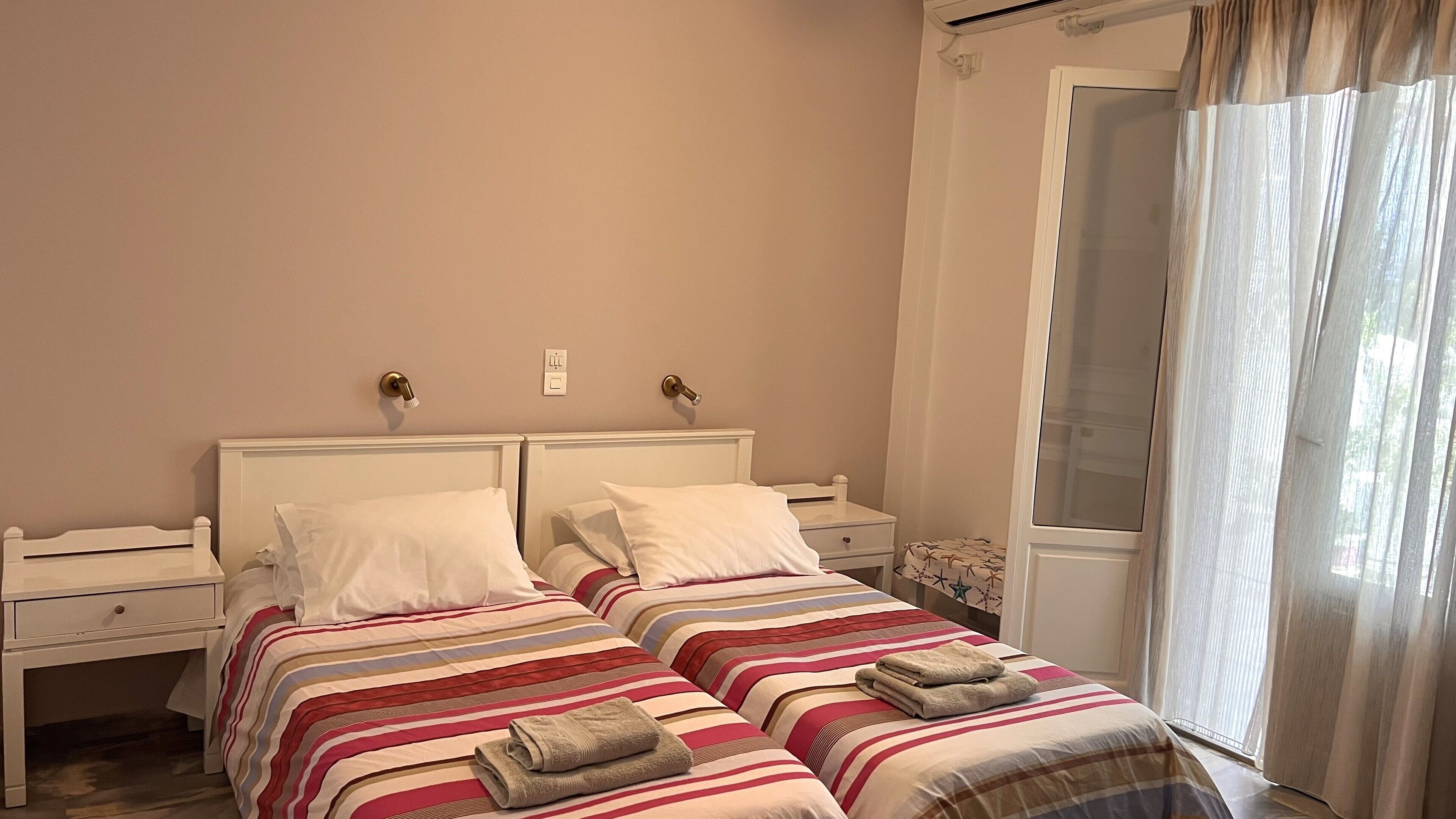 Una cama doble con ropa de cama a rayas y dos mesitas de noche.