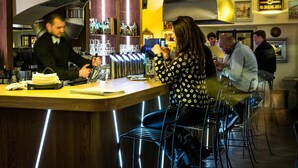 A bar area with a curved counter, bar stools, and a 'No Smoking Area' sign. - Hotel U Schnellu (Prague)