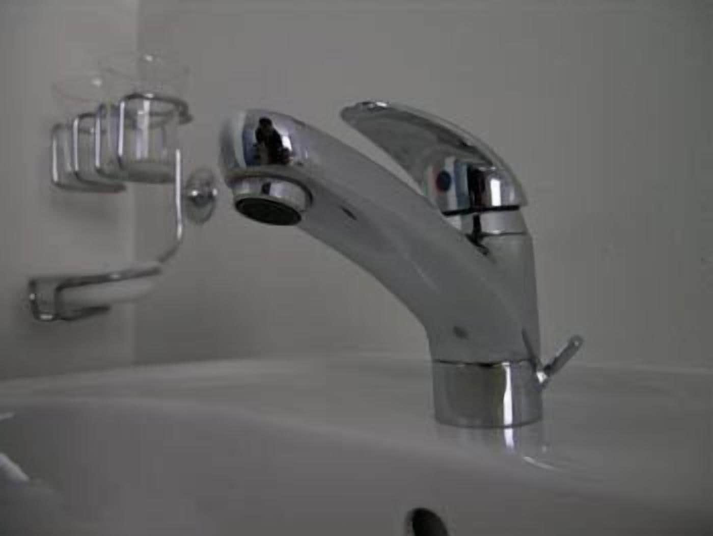 Un lavabo de salle de bain avec un robinet chromé et un distributeur de savon.