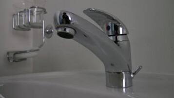 Un lavabo de salle de bain avec un robinet chromé et un distributeur de savon.