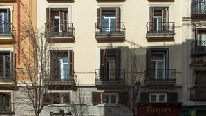 A multi-story building with balconies, a storefront, and a sign that reads "Riviera". - Suites You Zinc (Madrid)