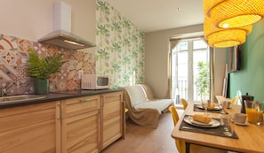 A modern kitchen with a microwave, sink, and wooden cabinets. - Suites You Zinc (Madrid)