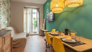 A modern room with a dining area, a bed, and a view of the outdoors. - Suites You Zinc (Madrid)
