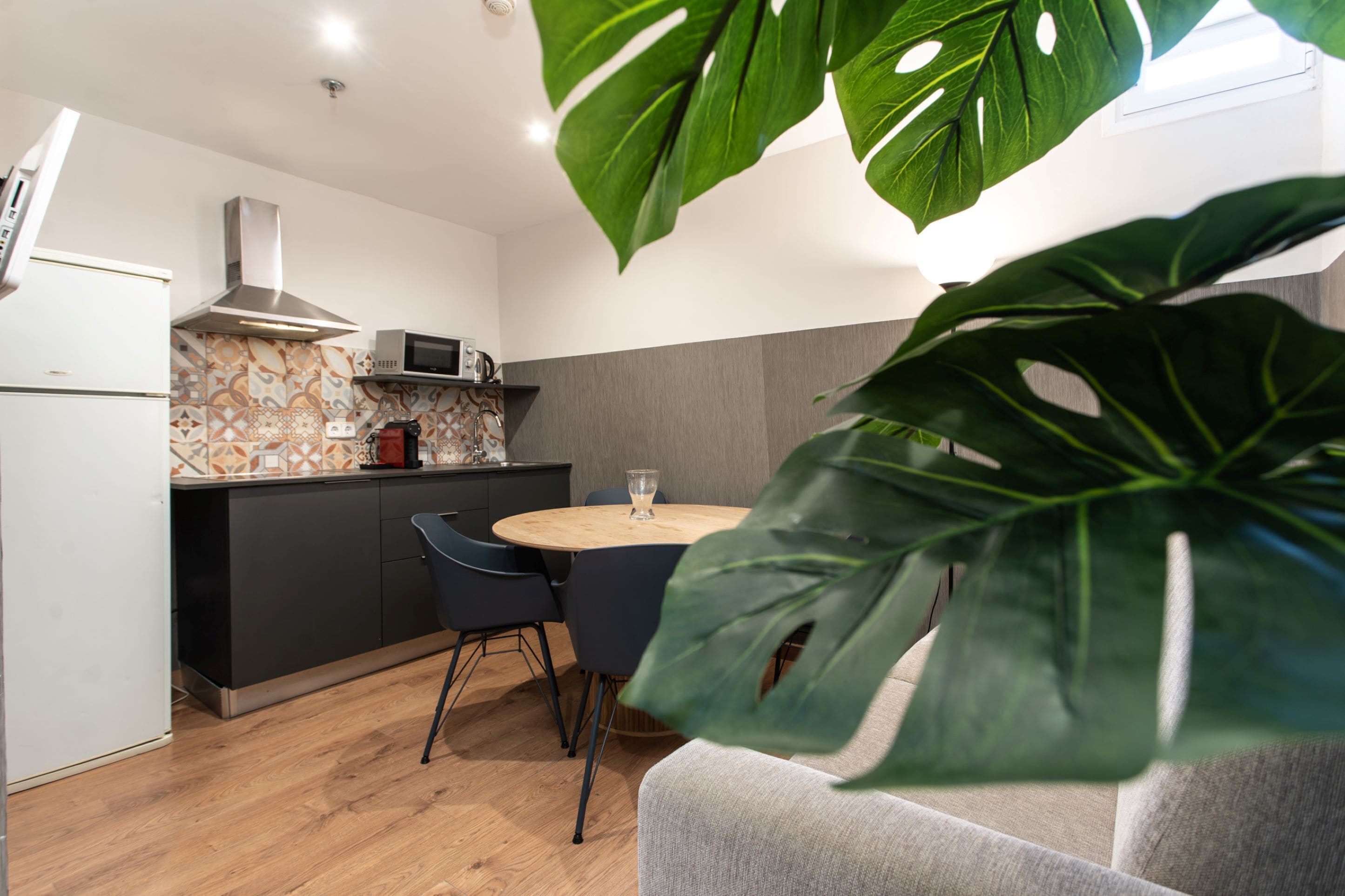 Una cocina moderna con una isla central, armarios oscuros y un microondas.