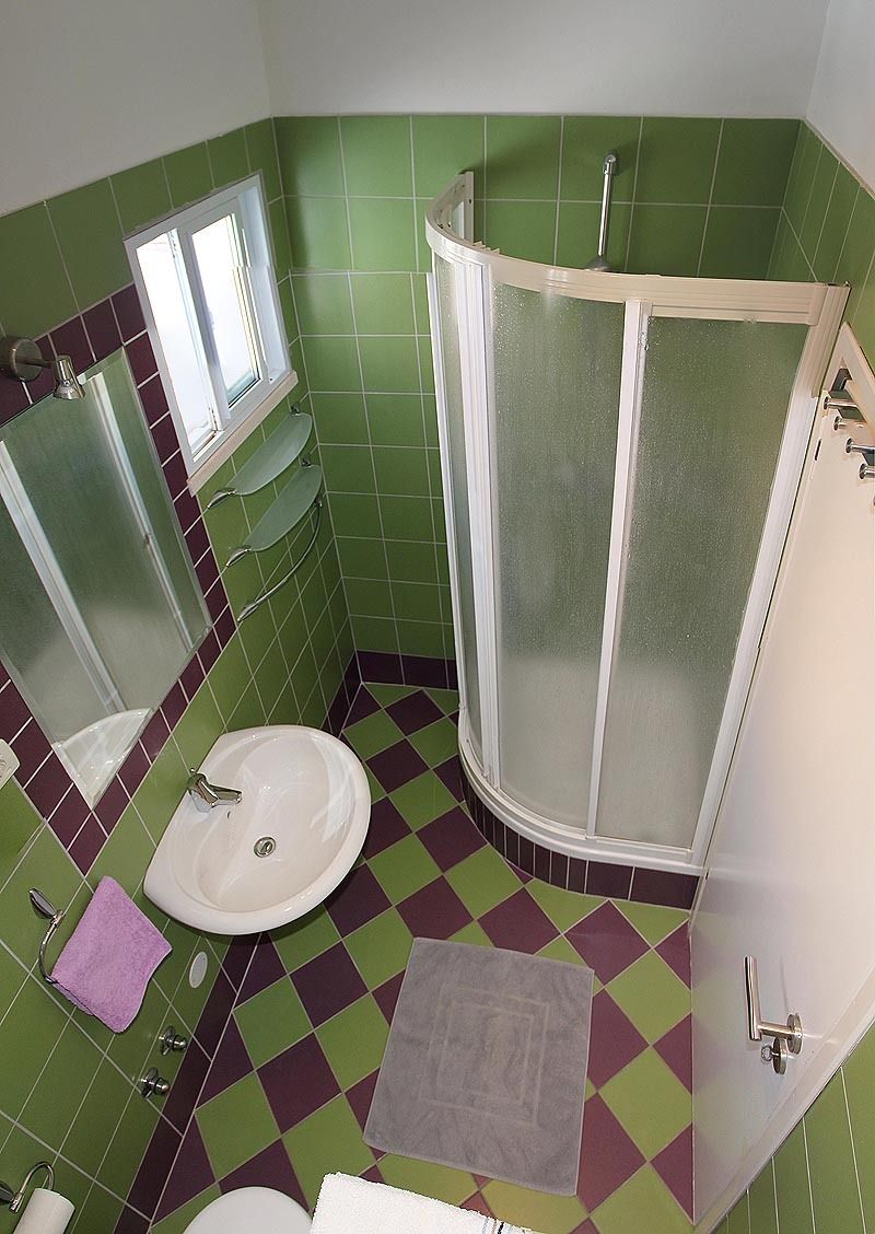 A bathroom with a shower, sink, and a mirror.