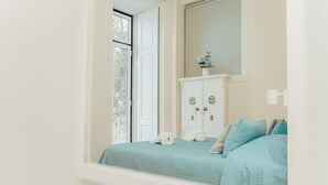 Un dormitorio con cama, cómoda y ventana.