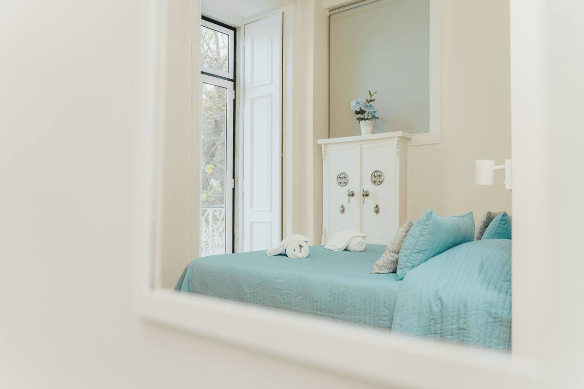 Un dormitorio con cama, cómoda y ventana.
