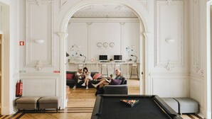 Amplia habitación con mesa de billar, chimenea y zona de estar con sofás.