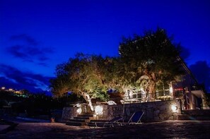 Vista frontal de la propiedad por la tarde o noche