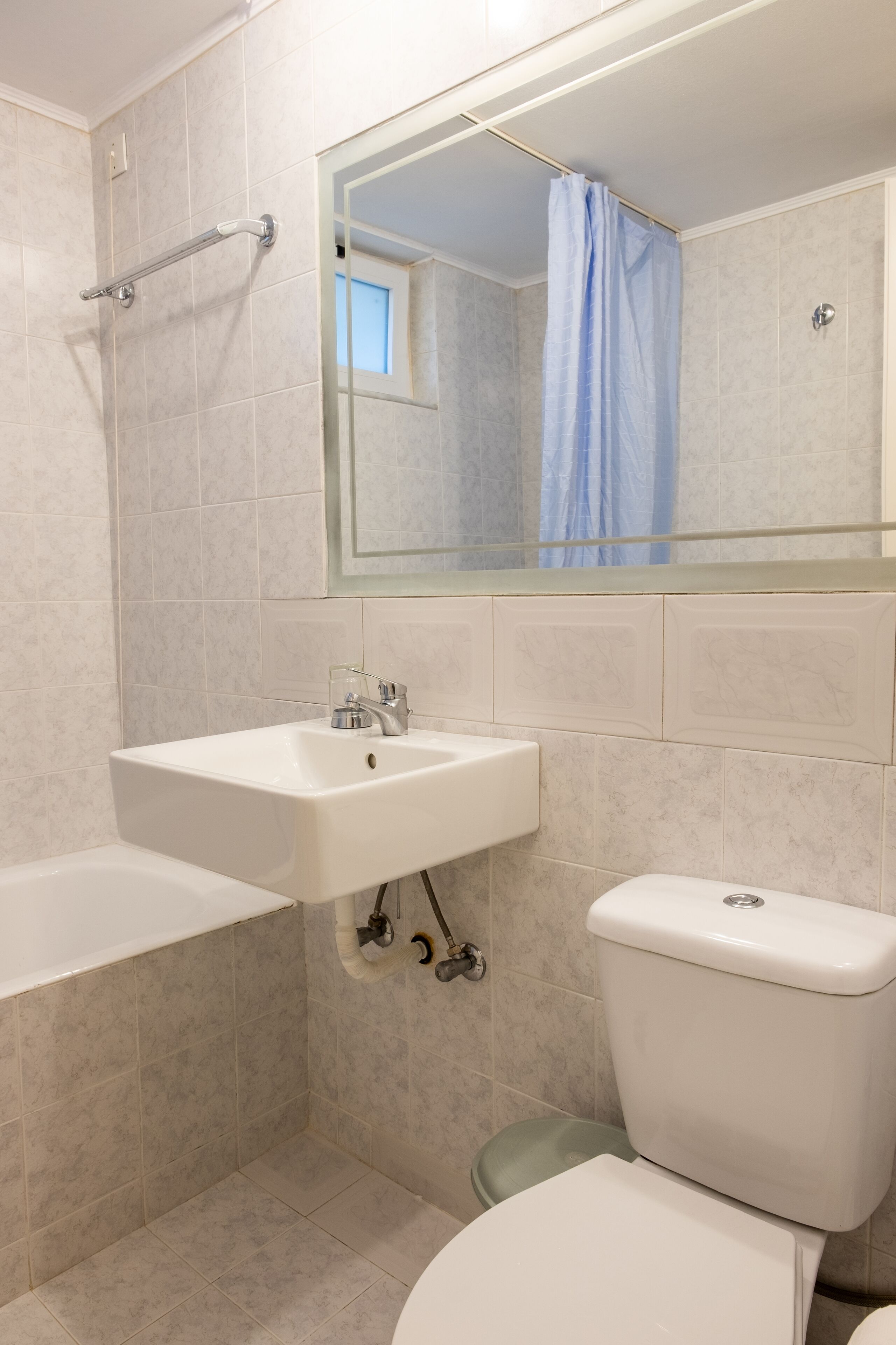 A bathroom with a white sink, a toilet, and a shower area.
