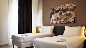 A hotel room with two beds, a large window with curtains, and a cityscape painting on the wall. - Nuovo Hotel Italia (Abbiategrasso)