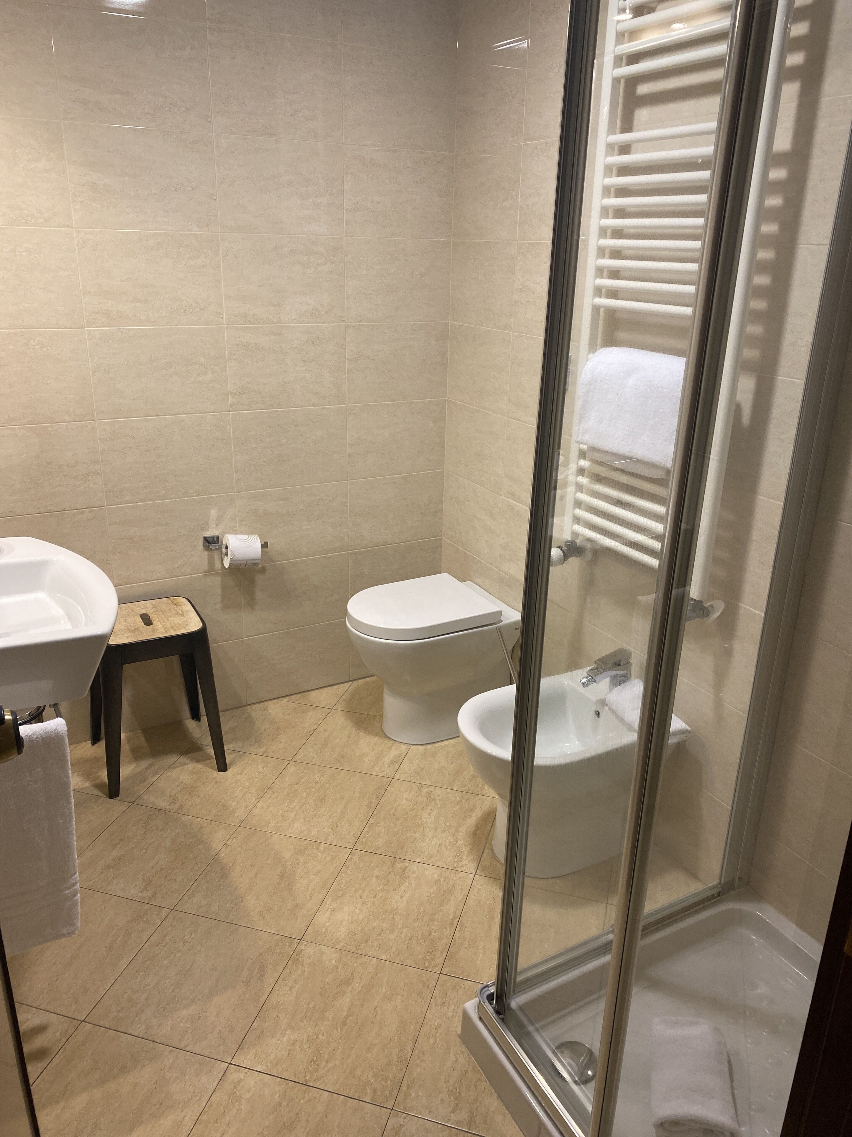 A bathroom with a toilet, sink, and shower.