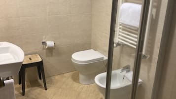 A bathroom with a toilet, sink, and shower.